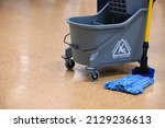 Small photo of Microfiber mop and bucket for indoor cleaning. Janitorial maintenance in public facility. Mop bucket floor care