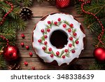 Traditional homemade christmas cake holiday dessert with cranberry in new year tree decorations frame on vintage wooden table background. Rustic style. Top view