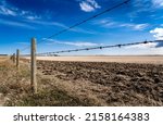 A Barbed Wire Fence With Wooden ...