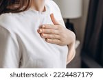 Small photo of Close-up of ill young caucasian female putting hand on chest, feels discomfort. Having pain in chest, Gastroesophageal Reflux Disease have frequent belching. Healthcare medical and people concept