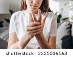 Cropped shot unhealthy female massage hand with wrist pain, rheumatoid arthritis. Young woman suffer from numbing pain in hand, numbness fingertip, arthritis inflammation, peripheral neuropathies