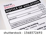 Small photo of Plain notice of violation ticket for building bylaws. Close up. Bylaw infraction. Strata or rental property management tool to warn and enforce rules.