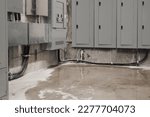 Small photo of Electrical room with water flooding ground. Below-grade service room or basement with water from flood, pipe burst or rain overflow. Immediate action required to prevent power loss. Selective focus.