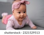 Small photo of A baby girl doing tummy time, an infant small girl. Newborn premature baby.