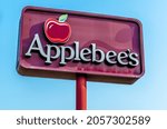 Small photo of Port Huron, MI USA - September 11, 2021: Horizontal, medium closeup of "Applebee's" casual dining restaurant's outdoor, freestanding, brand and logo signage on a bright sunny day with clear blue sky.