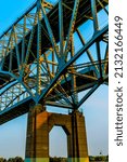 Small photo of Port Huron, MI USA - September 11, 2021: Vertical, medium closeup of the "Blue Water Bridge" spanning the Saint Clair River between the U.S. and Canada in the soft light of sunset.