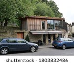Small photo of Roadside two story cafe lower stone built upper large glass windows and wood cladding with rumpus sign in brown letters trees in background Huddersfield Yorkshire England 27/08/2020