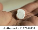 Small photo of Eindhoven, The Netherlands, April 14 2022. Paracetamol tablets or pills in a womans hand. Medicine, analgesics (painkillers) to reduce and treat headache, toothache, back and period pain, cold or flu