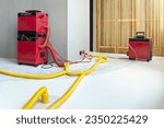Water damage restoration service for a leaking home environment with industrial air movers, dehumidifiers and pipes to remove water and moist from the wet floor. Repair the house. Household insurance