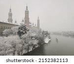 High resolution photograph of Zaragoza, taken under a great historical snowfall where you can see the Basilica del Pilar completely covered in snow, the Ebro River with its icy waters and the Stone Br