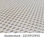 Small photo of Light yellow, rubberized, mesh, anti-slip carpet underlay - on a white background (macro, angle, texture).