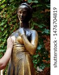 Small photo of woman's hand is touching the bronze Statue of Juliet Capulet in her house backyard. Courtyard of Juliet's house in Verona, Veneto, italy