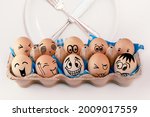 Small photo of Easter eggs with different faces in eggbox and round plate with cutlery, knife and fork. Types of temperaments. Sanguine, choleric, angry, phlegmatic, happy or melancholic. Face illustrated on eggs