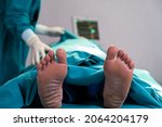 Small photo of Selective focus at feet of pass away patient while doctor covering face inside of the surgery operation room in the hospital. Illness and death concept.