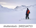 A man on skies in the snowy mountains of Jotunheimen in Norway. Randonee Skiing the sunset. 