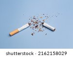 Small photo of Cigarettes are destroyed on a blue background. Smoking cessation concept. Copy Space