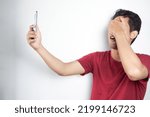 Small photo of man is shocked to see social media on his cellphone displaying obscene or vulgar content so he reflexively closes his eyes