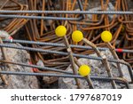Small photo of Steel reinforcement rebars with yellow protection caps. Covers protect workers from impalement on hazardous protruding metal thread bars rods used during construction pile process in building sites.