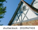 Gable wall of typical half-timbered house with brick first floor in Germany in front of blue sky