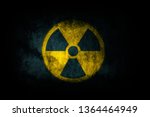 Nuclear energy radioactive (ionizing atomic radiation) round yellow symbol shape painted on massive concrete cement wall texture dark background. Nuclear radiation or radioactive alert warning danger.