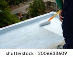 Small photo of Hand painted gray flooring with paint rollers for waterproof, reinforcing net,Repairing waterproofing deck flooring. roof, floor.