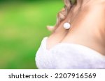 Bride's midsection, detail of necklace and cleavage with bustier white dress, wedding ceremony