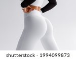 Fitness model in leggings with beautiful buttocks. 