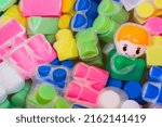 Small photo of Washing of children toys, plastic building blocks with figurines. A smiling little fellow and colorful cubes float in the foaming water. The concept of hygiene, cleanliness. Safety and disinfection
