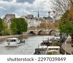 Small photo of Paris, France - April 11 2023: tour cruise boats on the seine river near the ile de la cite and pont neuf bridge