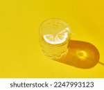 Yellow lemonade on solid background with soda and lemon. Close-up view