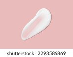 Small photo of A dab of cosmetic cream. Light, smooth surface. Texture of spreadable cream. Liquid cream smear. On a pink background.