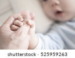 Little newborn baby holding parent's one hand, close-up macro shot. Focus on foreground. The touching and lovely moment. Concept of support, hope, love, bonding and care, hold on...