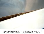 Small photo of unglued defective chipboards white reflective table side