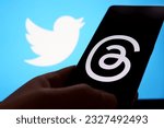 Small photo of Threads vs Twitter concept. Threads app logo seen on screen of smartphone and Twitter logo on the back. Stafford, United Kingdom, July 4, 2023