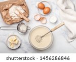 Preparation of dough for home pancakes for Breakfast. Ingredients on the table - wheat flour, eggs, butter, sugar, salt, milk. Selective focus