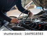 Professional mechanic man holding timing belt of a car for repair and preventive maintenance car in garage