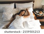 Young female 20 years old in comfy bedclothes watching sweet dreams enjoying sunday morning for long napping in hotel, Caucasian woman lying in cozy bedroom sleeping during lazy day on weekend
