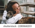 Small photo of Carefree Caucasian female cynologist resting and hug during leisure pastime with mongrel puppy dog from shelter, happy woman with pet enjoying weekend for communication with fluffy best friend