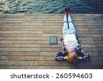 Top view young woman lying on a wooden jetty enjoying the sunshine,tourist girl in bright glasses lying on jetty by river, vintage photo of relaxing young woman in nature with tablet, cross process