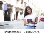 Portrait of a stylish hipster girl using her digital tablet for navigation in urban setting, attractive latin woman reading digital e-book on touch pad during walking in summer day, copy space area