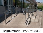 Shiny steel handrails at the entrance to the store. Handrails and ramp for disabled people.