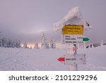 Small photo of Tourist signpost on Brona Mountain Pass in winter day. Poland. Translation: Brona Pass 1408 m above sea level, Small Babia Mountain 0.30 h, Medralowa 2.45 h, Babia Mountain 1 h