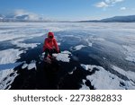 Small photo of Silhouette of woman in red down jacket on snowshoes on frozen lake Tornetrask (Tornestrask) around Abisko National Park. Sweden, Arctic Circle, Swedish Lapland