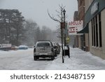 Small photo of OBERLIN, OHIO, USA - JANUARY 02, 2014: CArs parked on College Street in front of Apollo Movie Theater, on a snowy winter day.