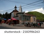 Small photo of BRAN, ROMANIA - MAY 26, 2014: Bikers with motorcycles parked by unique old building, with cupola and tin roof, on General Traian Mosoiu street, the main road through Bran village.