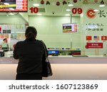 Small photo of CHINATOWN, SINGAPORE â€“ 26 DEC 2019 â€“ View of Chinese woman at the counter of a money transfer remittance company. The Chinese words read â€śZHONGGUO REMITTANCE"