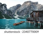 Braies Lake in the Dolomites mountains with forest trail in the background, Sudtirol, Italy. Lake Braies is also known as Lago di Braies. The lake is surrounded by a forest that is famous for its pict