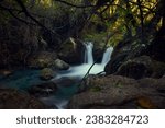 Small photo of Lush forest with a river flowing into the two little cascades and mightily between stones. Long exposure picture