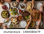 Small photo of large and generously covered with delicious dishes table, covered with a tablecloth on which there are various delicious dishes of Ukrainian cuisine: fried ribs, borsch, salads, cheese