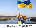 Mom and son stand high on roof of house against of sky and Dnieper River in Kyiv. Patriotism, drawing attention to war in Ukraine. Support Ukraine. Independence Day. faith in victory. stop the war